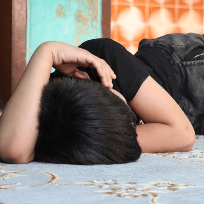 کودکی که در چهار دیواری غم اسیر شده است