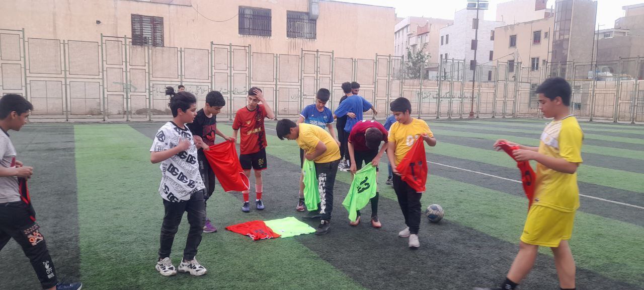 مربی تیم سایپا به کودکان مهرآفرین فوتبال آموزش می‌دهد
